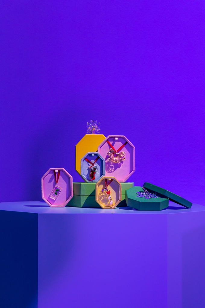Tiny rings displayed on a clear stand with purple backdrop.