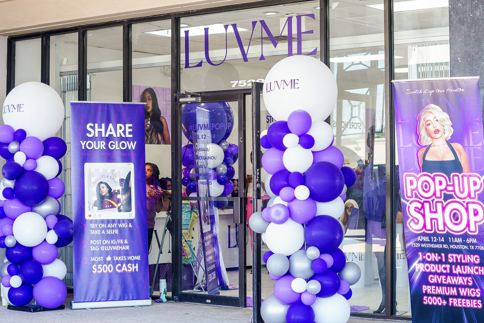 Step into a world of color with the stunning purple and white balloon arrangement outside the store during the luvme popup hair event in Houston, TX.