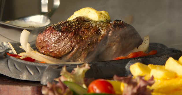 Saftiges gegrilltes Steak mit schmelzender Kräuterbutter, serviert im lateinamerikanischen Stil im Restaurant Los Latinos
