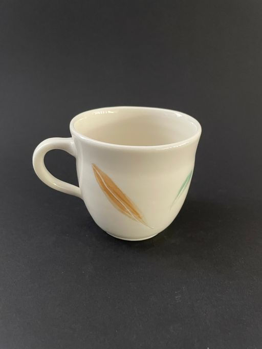 Miniaturbild: Tasse aus Porzellan mit grünen und braunen Blättern