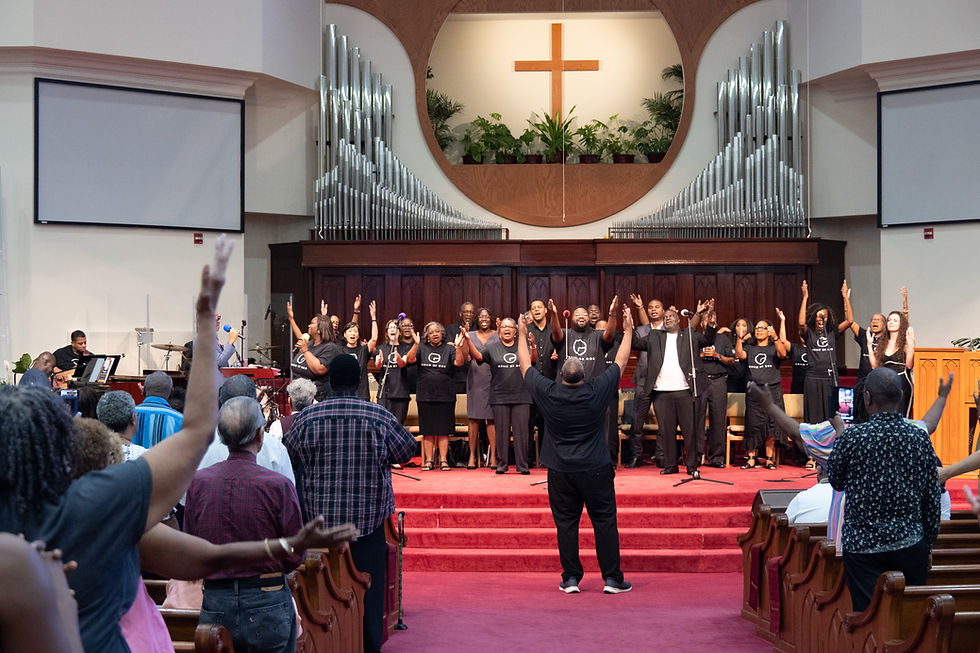Griffiths directing a full choir and band before a standing audience at the "My Story of Hope" concert.