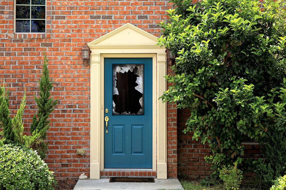 Broken front door window in a brick home, example of vandalism or break-in damage for home insurance claim support.