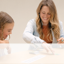 A teacher playing a math game with a student.