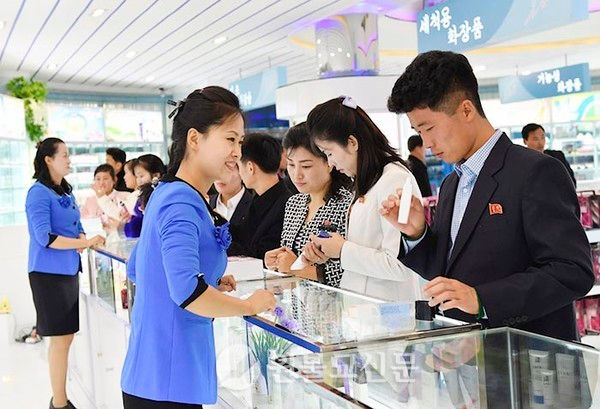 In 2018, citizens are seen selecting products while trying them firsthand at the cosmetics exhibition hall of the Pyongyang Cosmetics Factory.