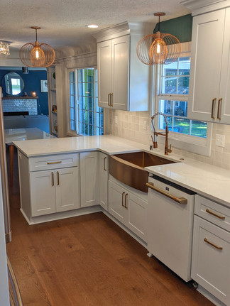 Custom kitchen remodel with wood flooring, tile backsplash, quartz counters, updated appliances, & new cabinets.