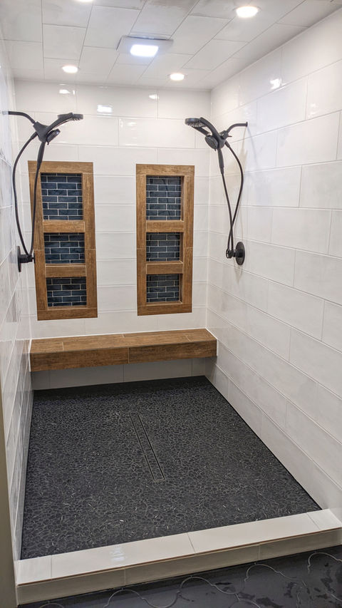 Custom tile shower and master bathroom remodel with built-in niches, bench, and linear drain.