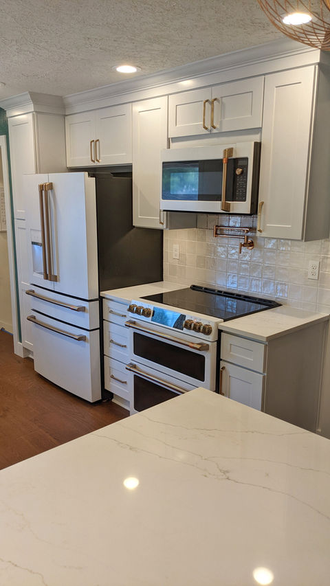 Custom kitchen remodel with luxury appliances, tile backsplash, quartz countertops, & wood flooring. 