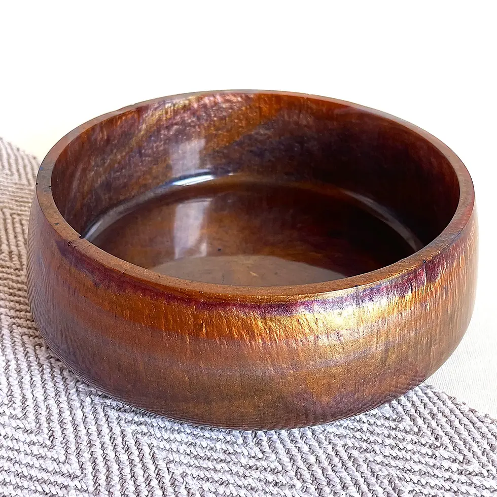 Sculptural resin bowl in warm bronze tones with a glossy finish, modern statement home decor piece