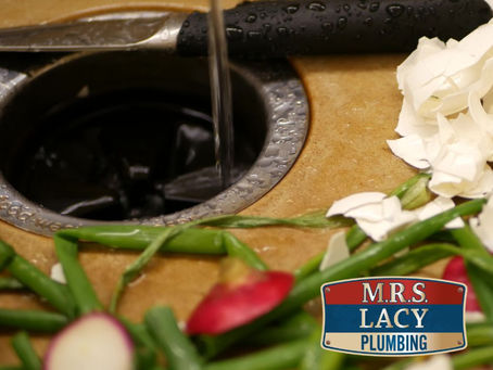 Knife and water stream over sink and garbage disposal with green veggies and peels. M.R.S. Lacy Plumbing logo in corner.