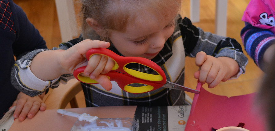 Child cutting paper in school actiity