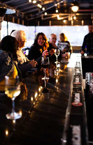 Guests enjoying wine and conversation at the bar inside Fulton Yards Coffeehouse & Spirits, a Cincinnati coffeehouse & spirit