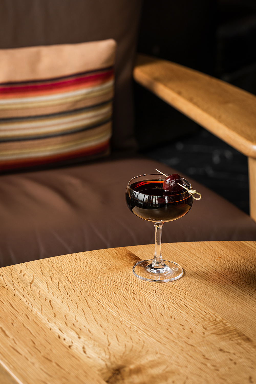“Single coupe cocktail on a table, minimal composition.”