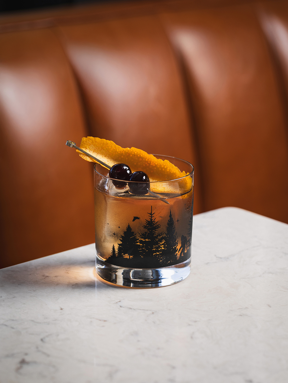 “Cocktail with foam in a coupe glass, bar setting.”