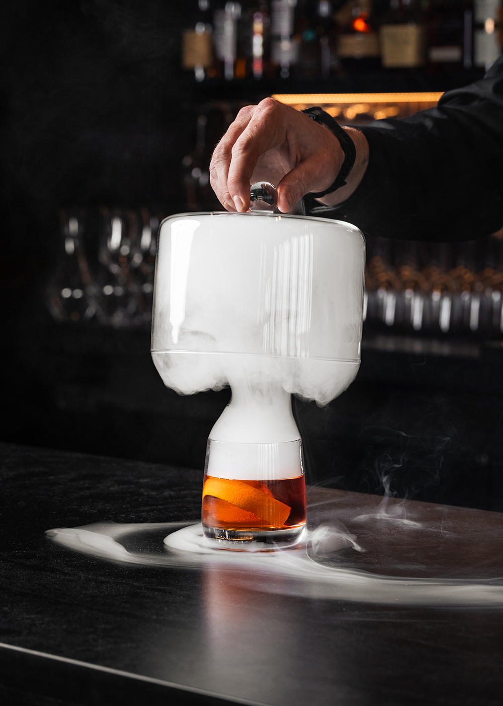“Cocktail served under a glass cloche with smoke, dramatic.”