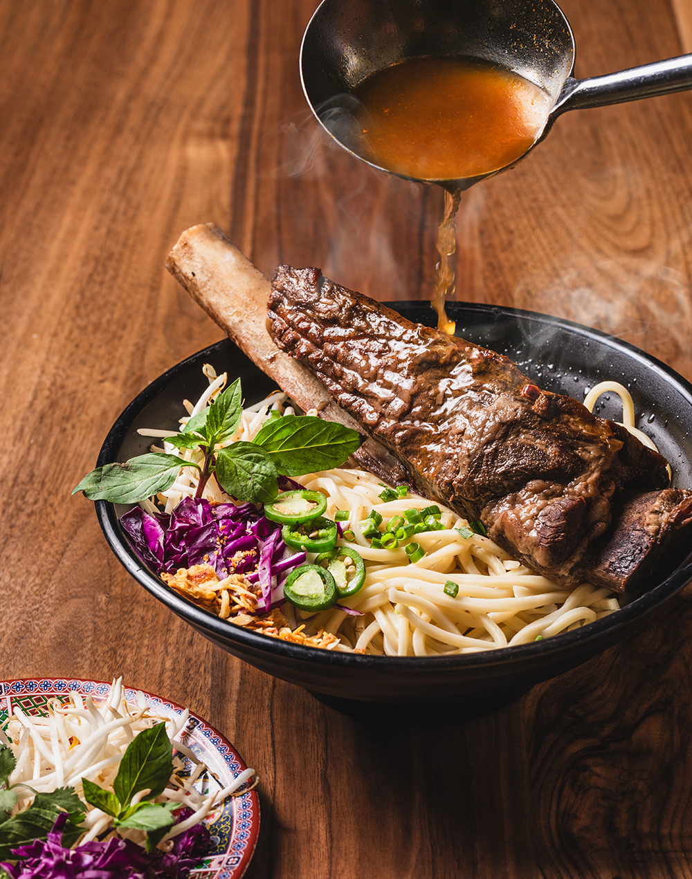 “Grilled meat plate with herbs and sides, overhead food photo.”
