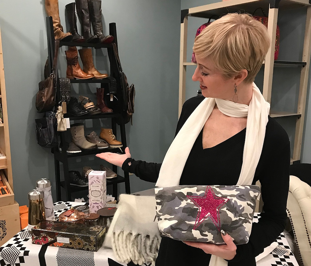 Lisa Berry pointing to a table full of gift-able items.