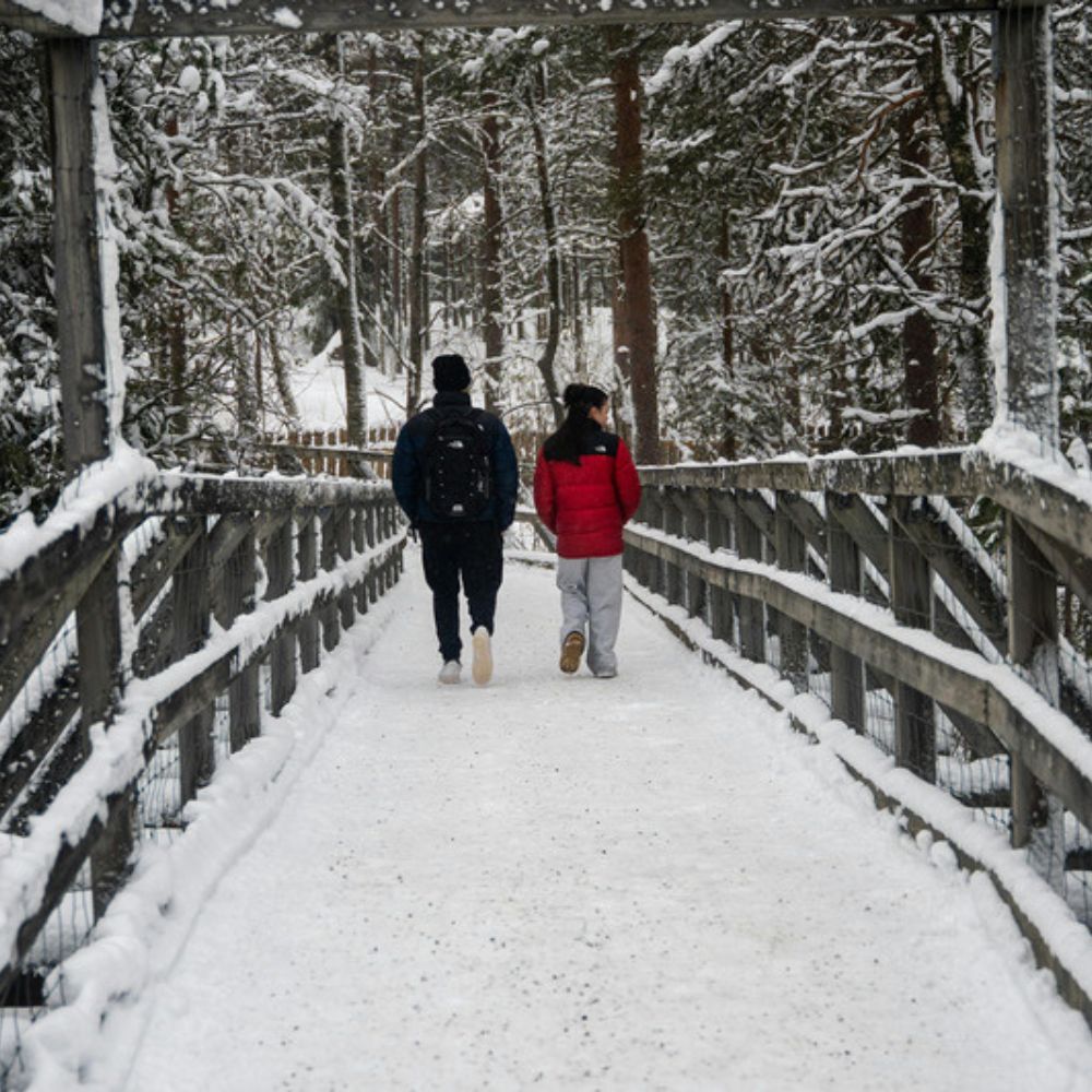 Paar spaziert auf verschneiter Brücke in Finnland