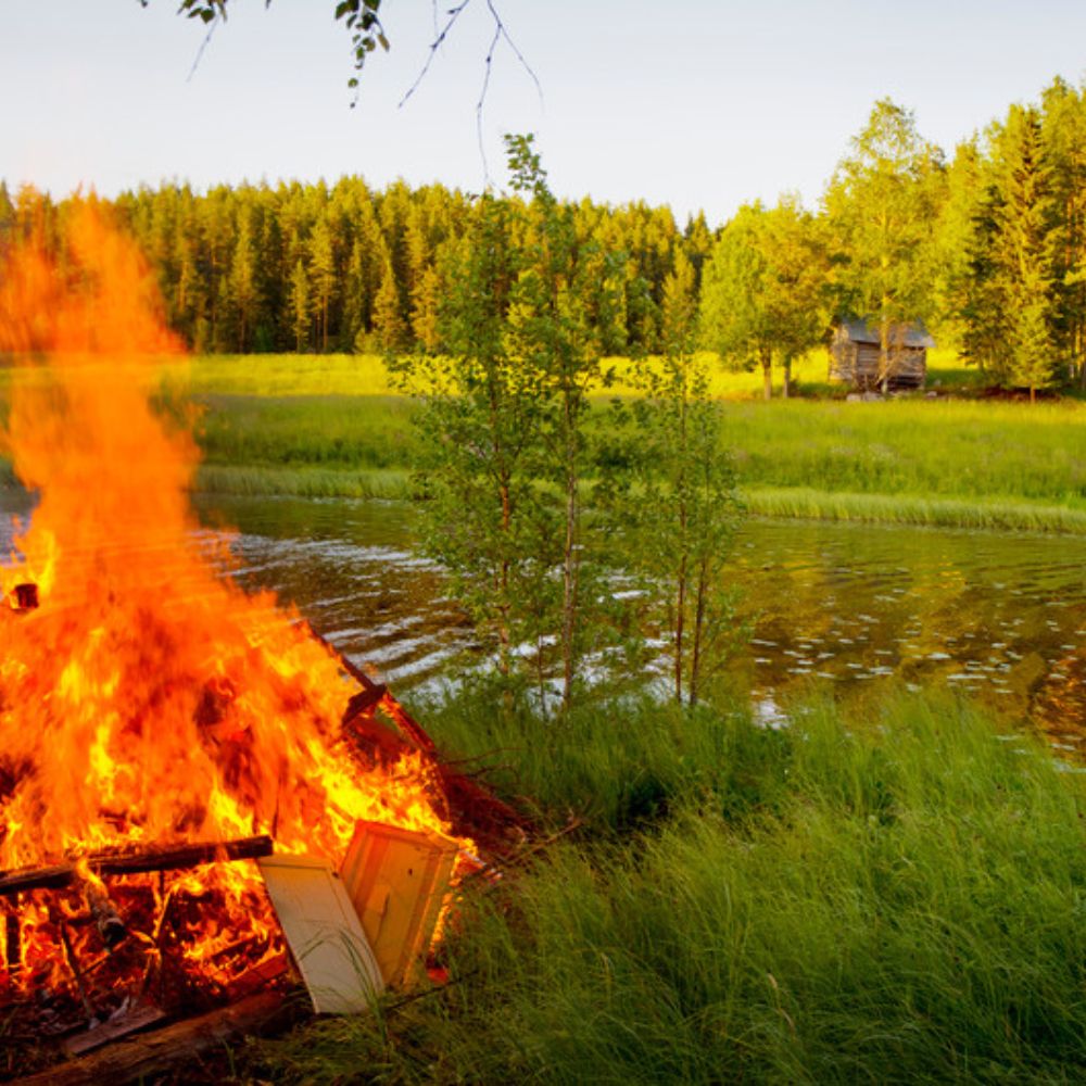 Lagerfeuer am finnischen See bei Mittsommer – Finnland im Herzen