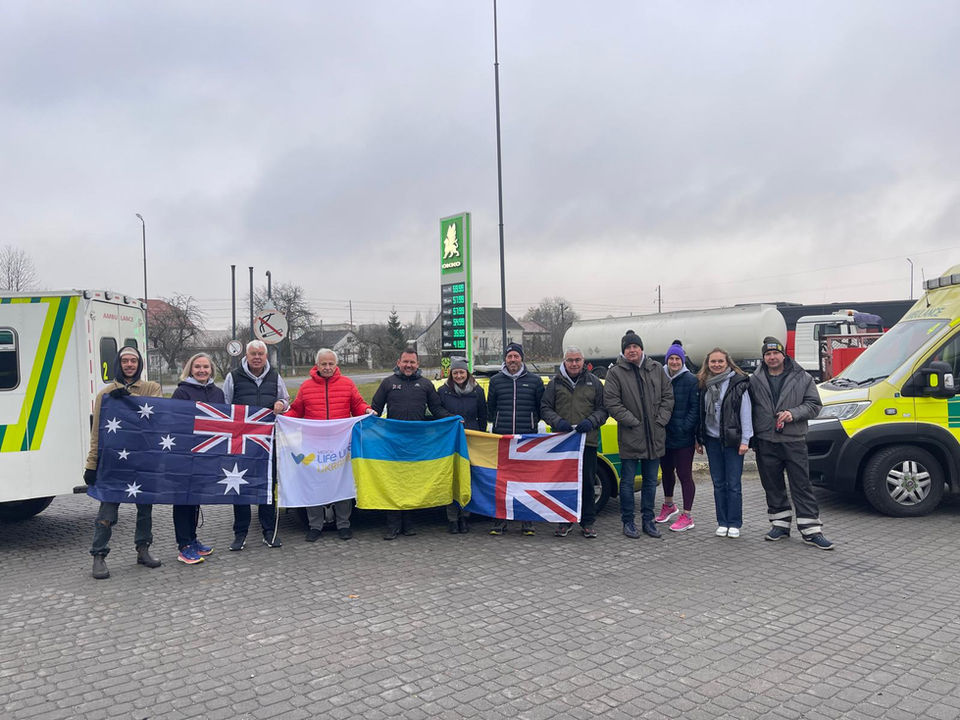 Our team of drivers and ambulance recipients stand in front of the delivered vehicles