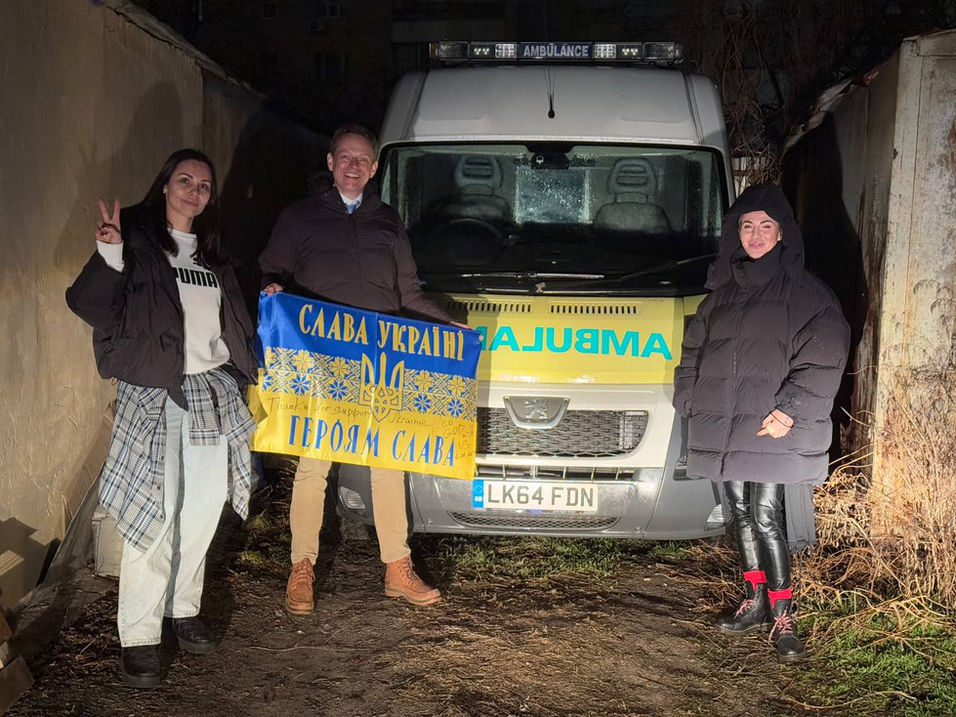 Committee member Dan stands next to the ambulance we delivered