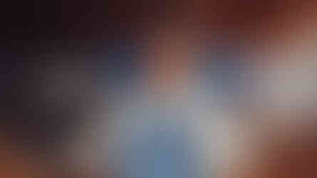 Barista wearing a blue Pluto Coffee + Art Café apron standing behind the café window with the scripted logo by MENR Studios.