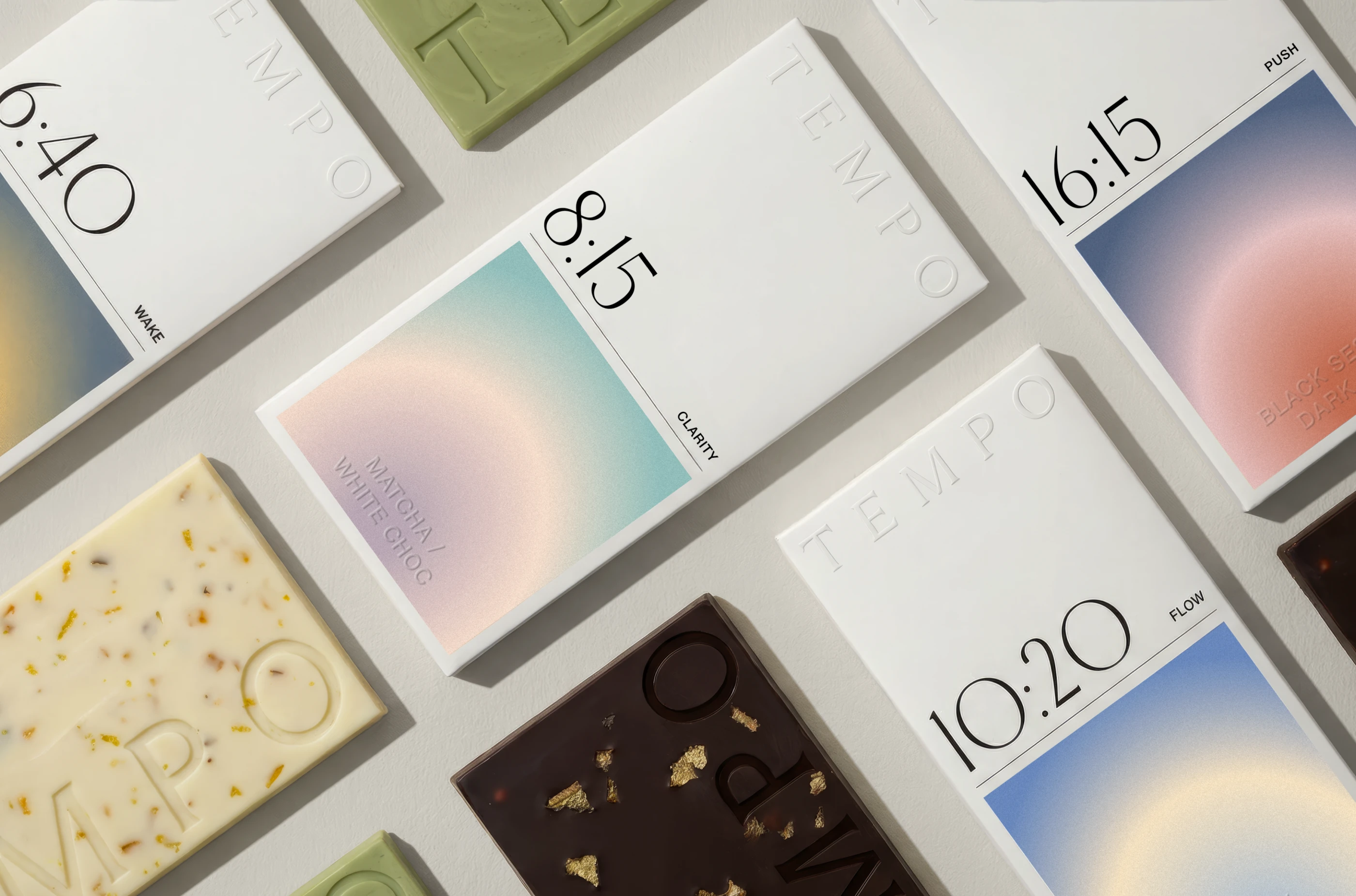 TEMPO chocolate brand identity and packaging design by LYM Design Studio featuring multiple white chocolate bar boxes with time-based labels, soft gradient artwork, embossed typography, and assorted chocolate bars.