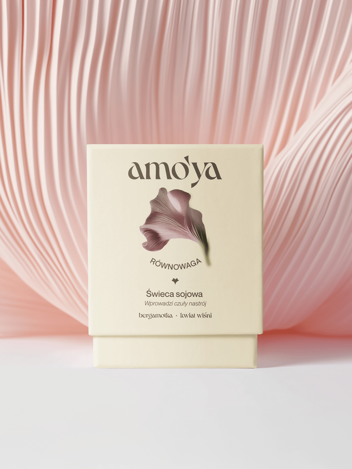 Amo’ya Równowaga soy candle box in cream packaging, featuring a pink abstract floral graphic against a sculptural blush petal backdrop.