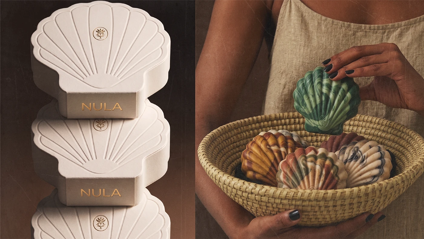 NULA shell-shaped soap packaging and lifestyle imagery featuring stacked cream boxes and a woven basket filled with colorful sculptural soaps.