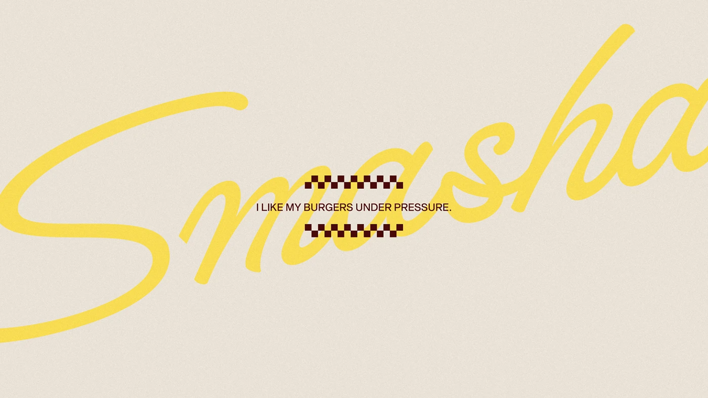 Minimal typographic composition featuring the Smasha script logo in bold yellow with the phrase “I like my burgers under pressure” centered on a textured neutral background.