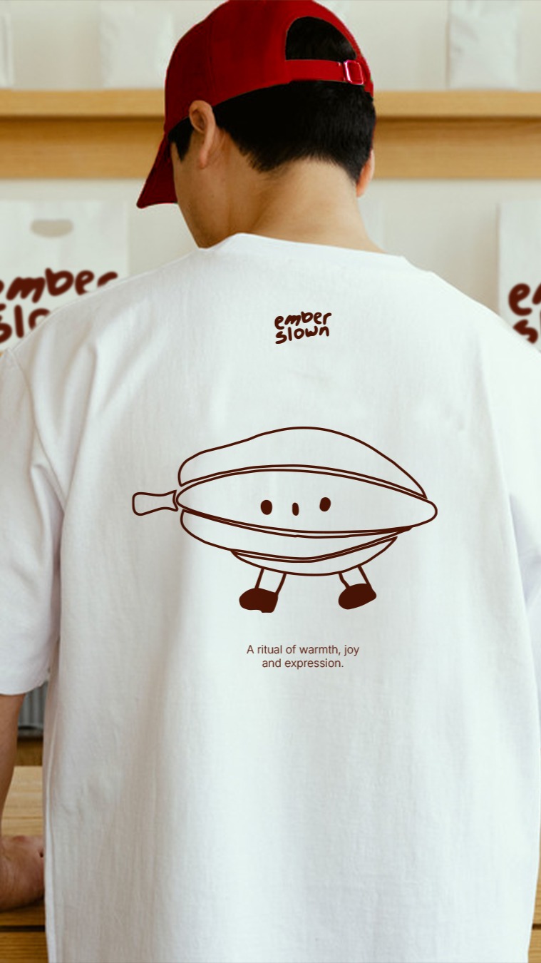 Person wearing an Ember Slown graphic t-shirt featuring the illustrated cacao mascot and playful chocolate brand identity design.