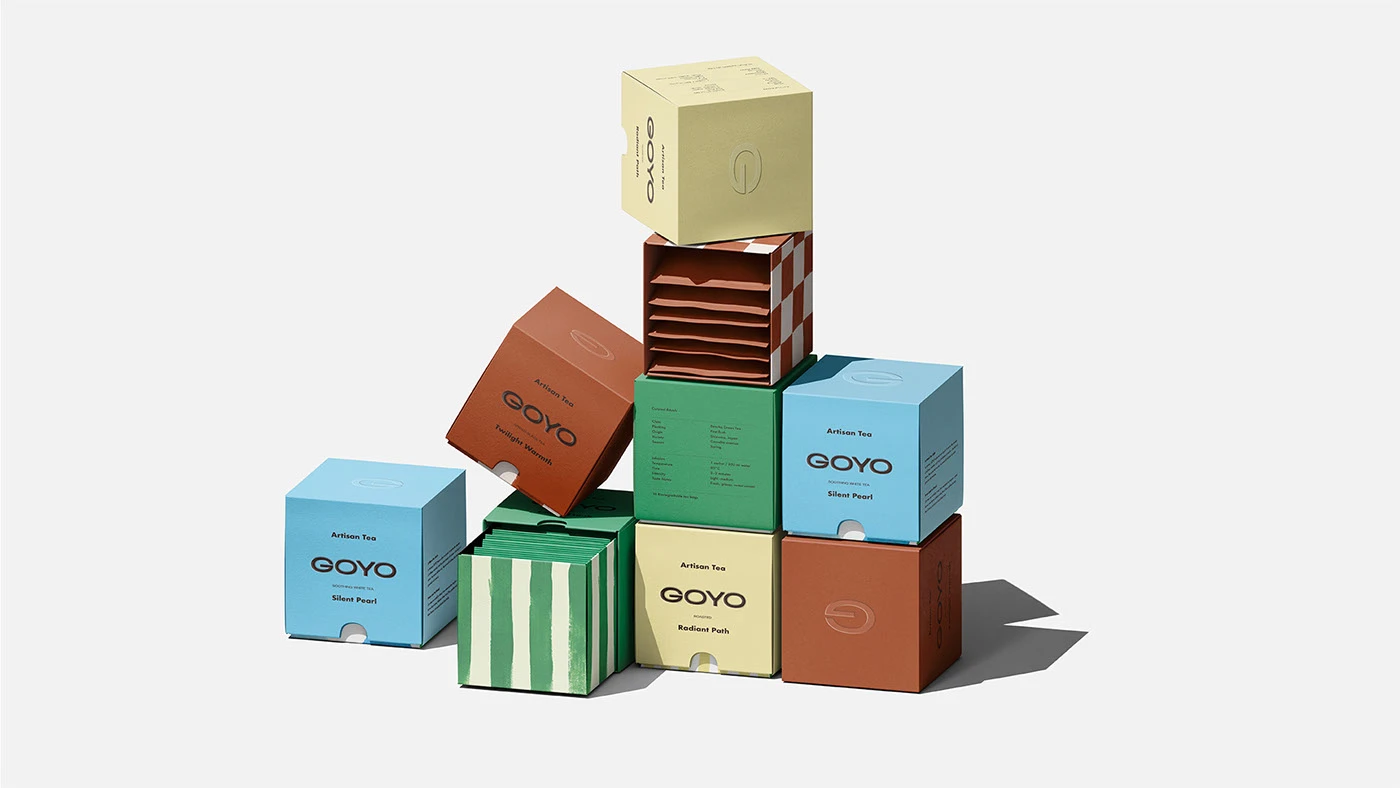 Stacked display of Goyo Tea packaging boxes in multiple colors and patterns, highlighting editorial typography, minimalist branding, and playful structural composition