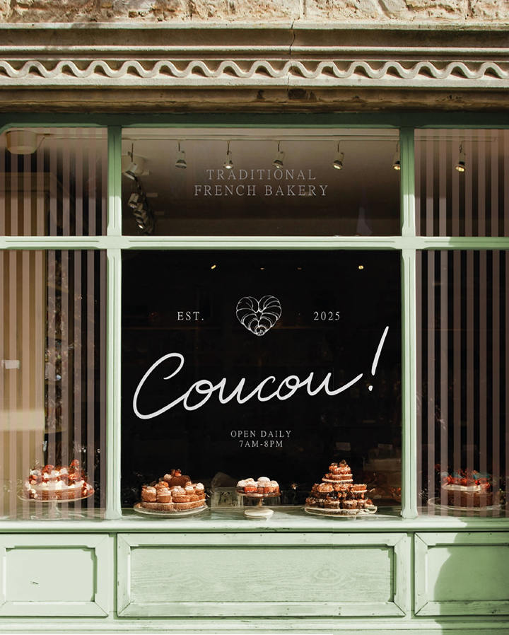 Coucou bakery storefront with hand-lettered logo signage and an elegant window display of traditional French pastries