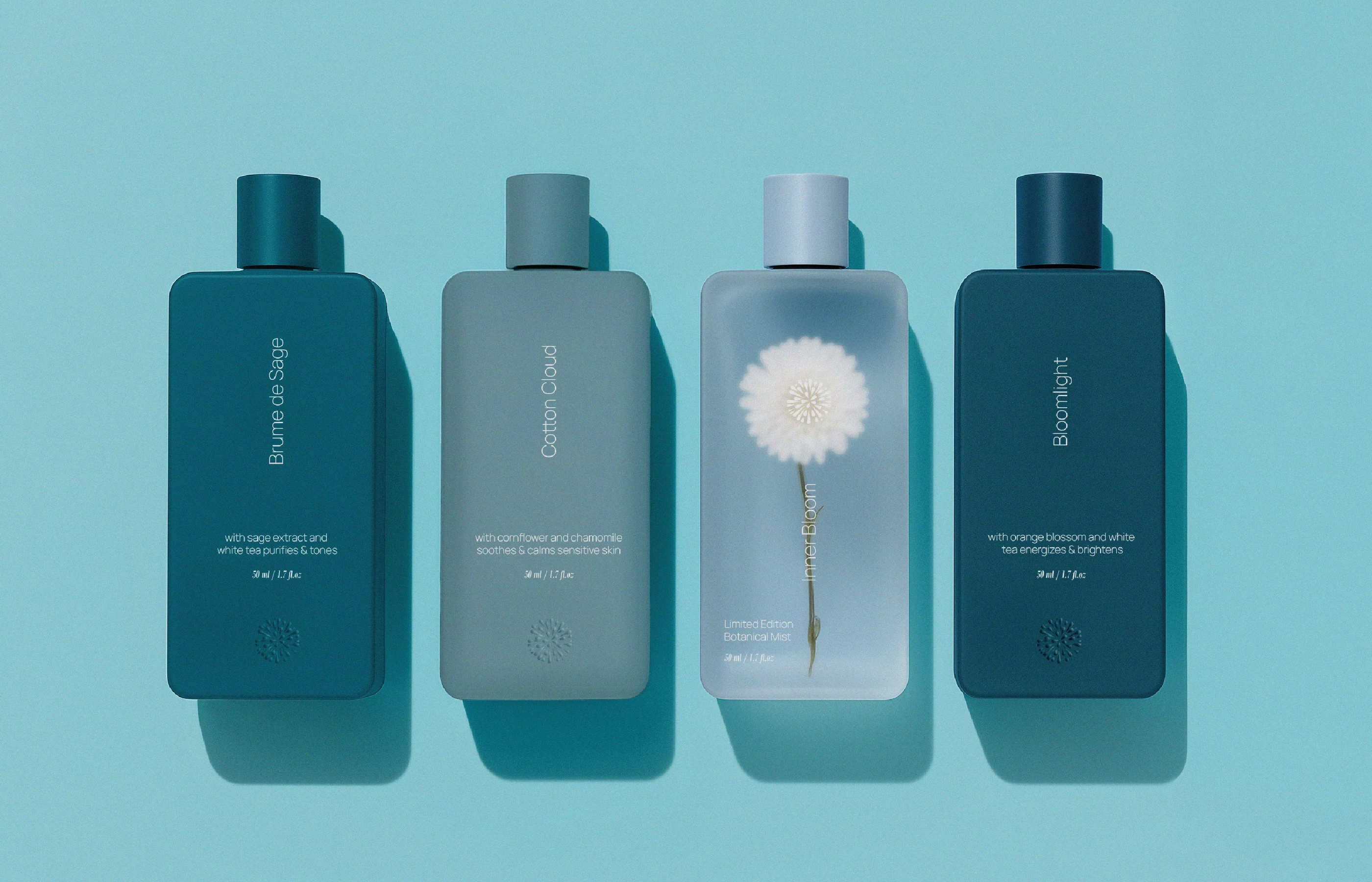 Clean studio shot of four Lumere skincare bottles in a gradient of dark teal to frosted light blue. Each bottle displays minimalist vertical typography, specific product names like 'Cotton Cloud,' and a small embossed mandala at the base.