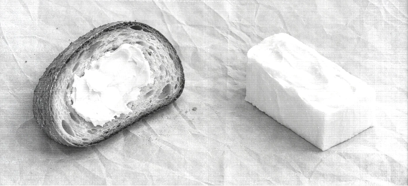 Black and white editorial photograph of sliced bread with butter styled in minimalist composition, referencing Archivio Coffee Cultura’s archival brand aesthetic.