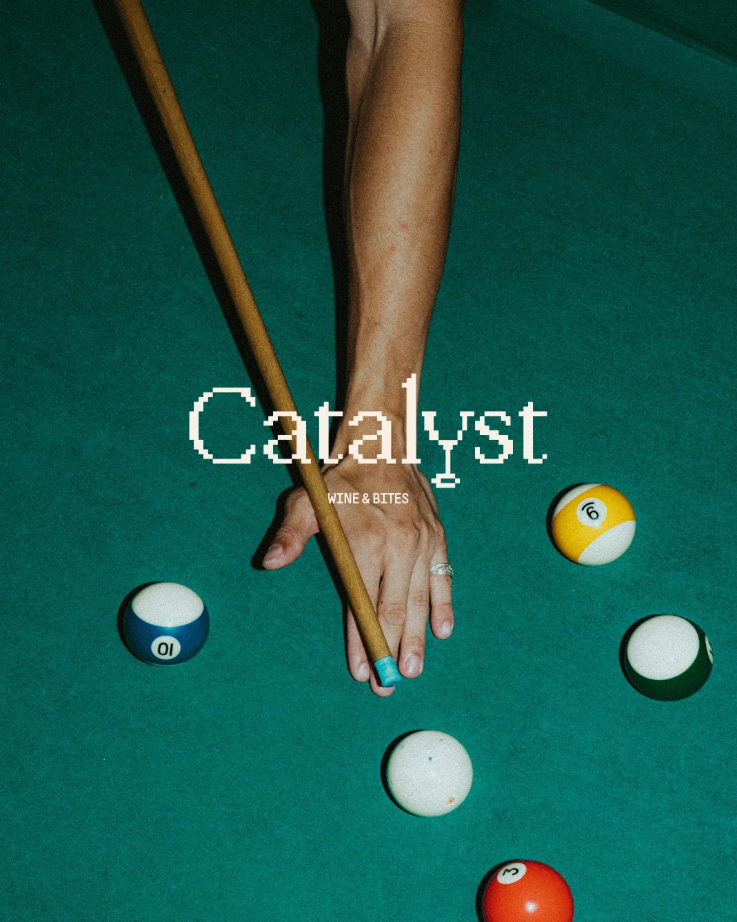 Top-down shot of a pool table with billiards balls and a white pixelated Catalyst logo overlay.
