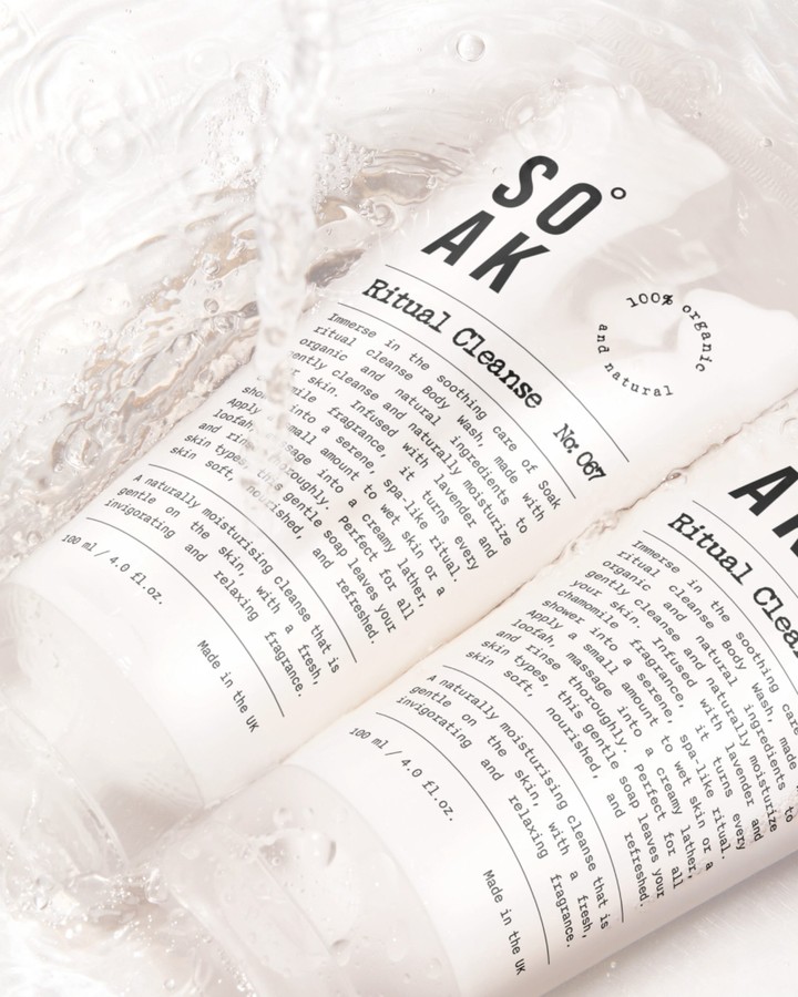 Soak Ritual Cleanse skincare tubes with black typography photographed in clear water with bubbles and bright reflections.