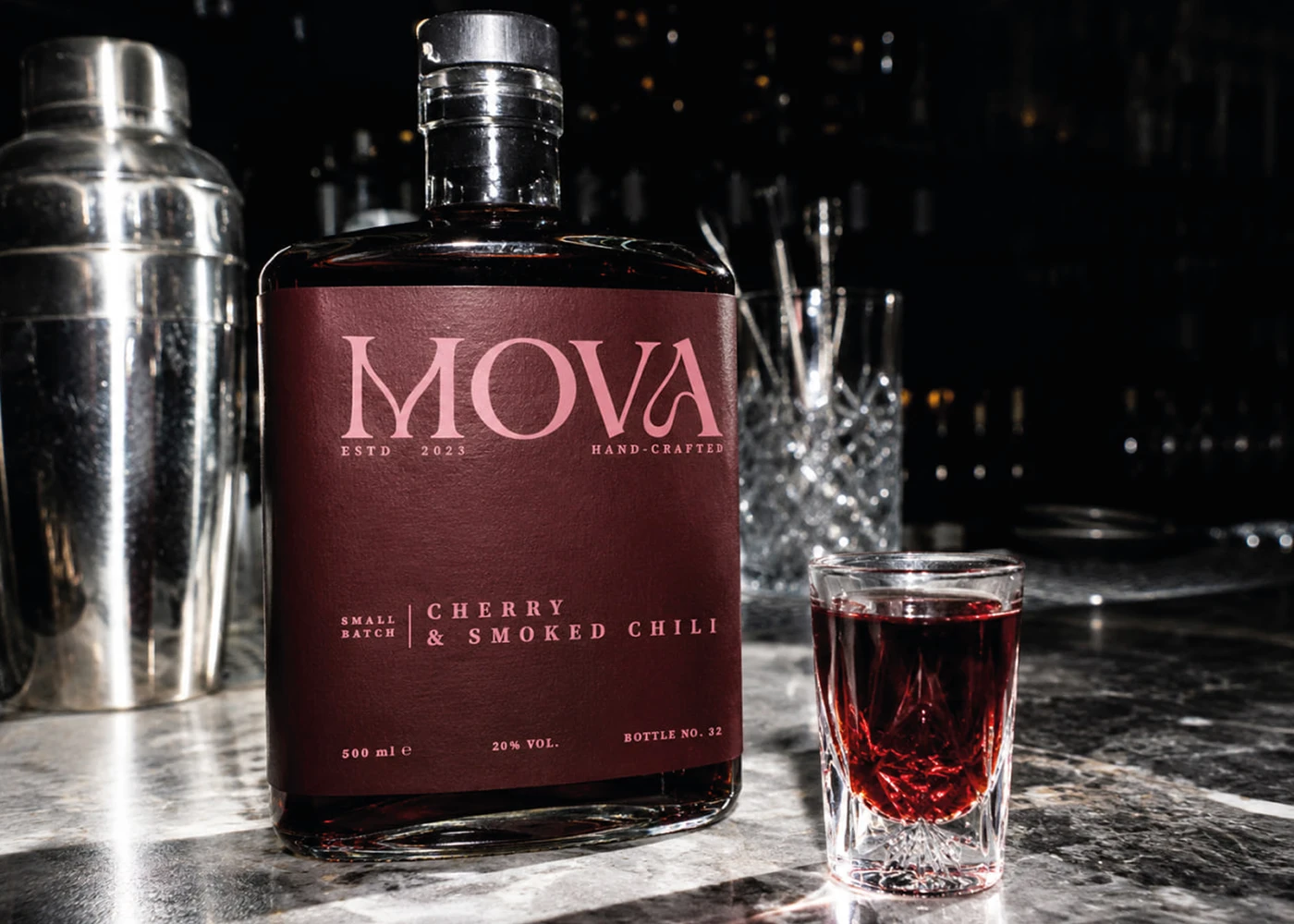 MOVA cherry and smoked chili fruit liqueur bottle with burgundy packaging and a filled tasting glass