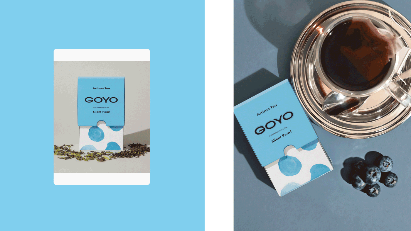 Lifestyle photography of Goyo Tea Silent Pearl packaging, featuring minimalist blue box design with watercolor dots alongside tea leaves, blueberries, and a glass teacup