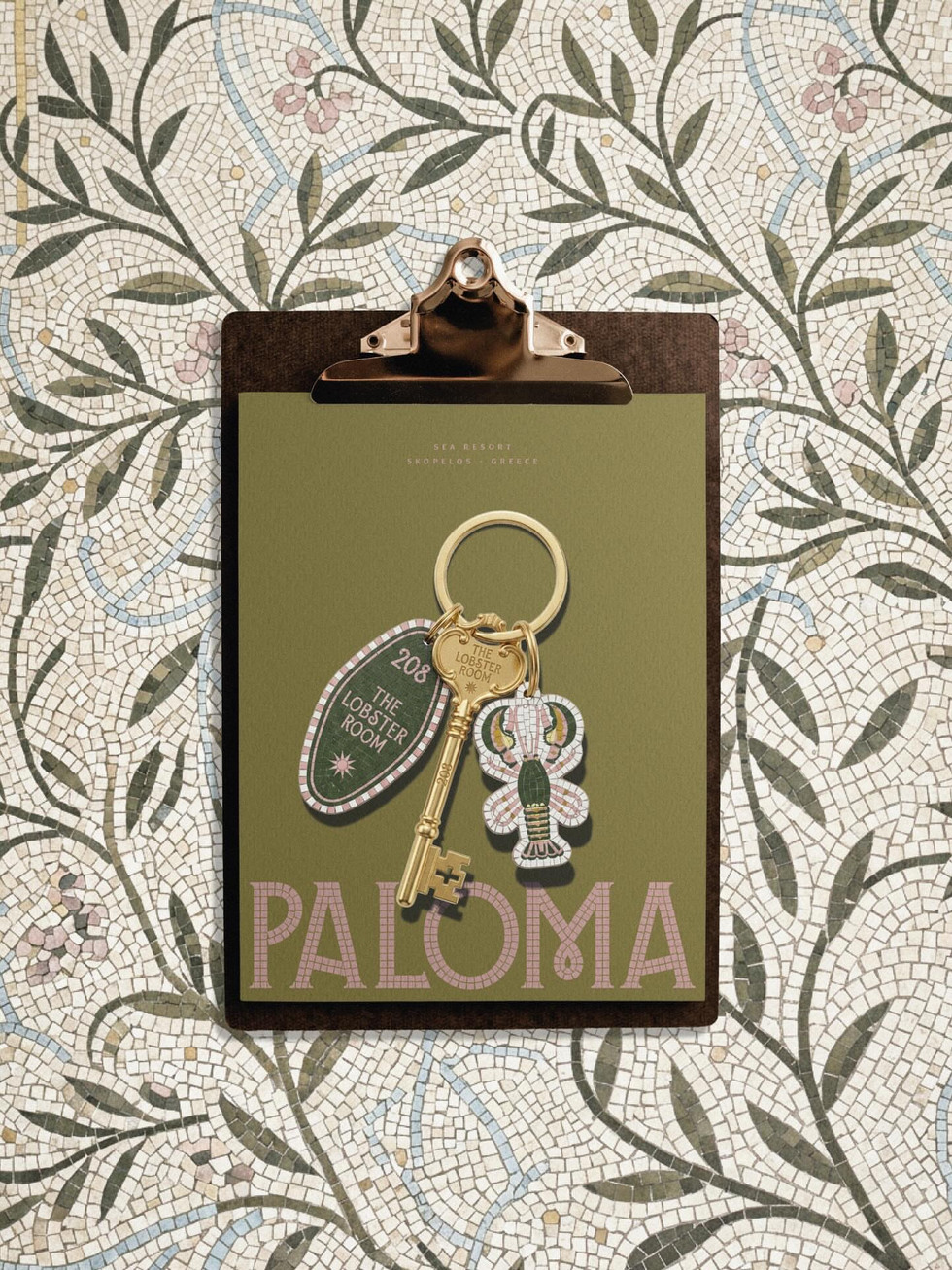 Paloma resort key and room tag design displayed on a clipboard over a floral mosaic tile background, showcasing the Mediterranean hospitality branding system