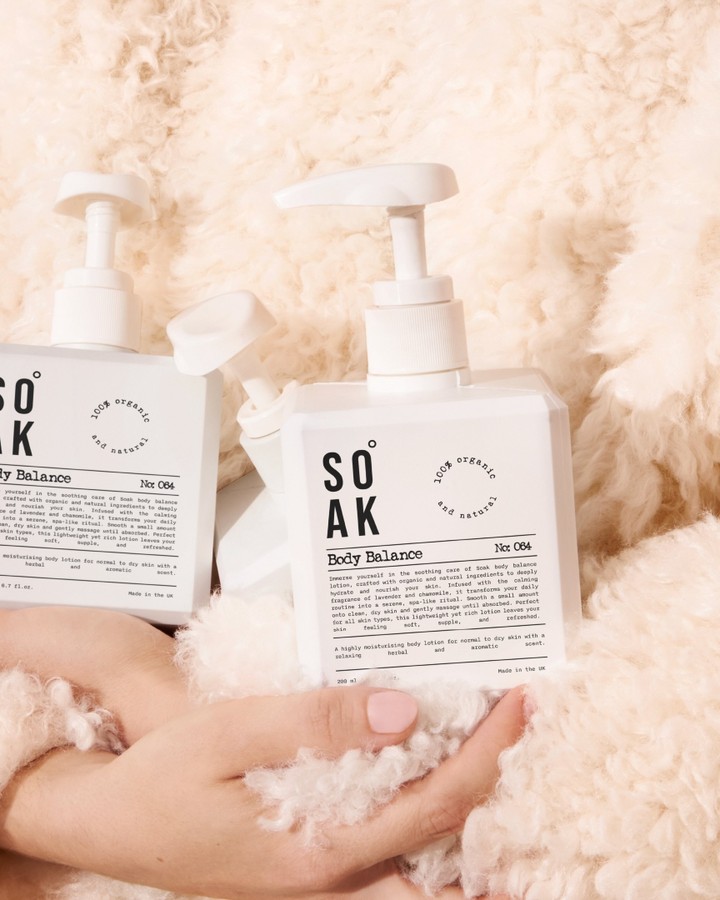 Soak Body Balance pump bottles with clean black-and-white labels photographed against soft cream wool texture.
