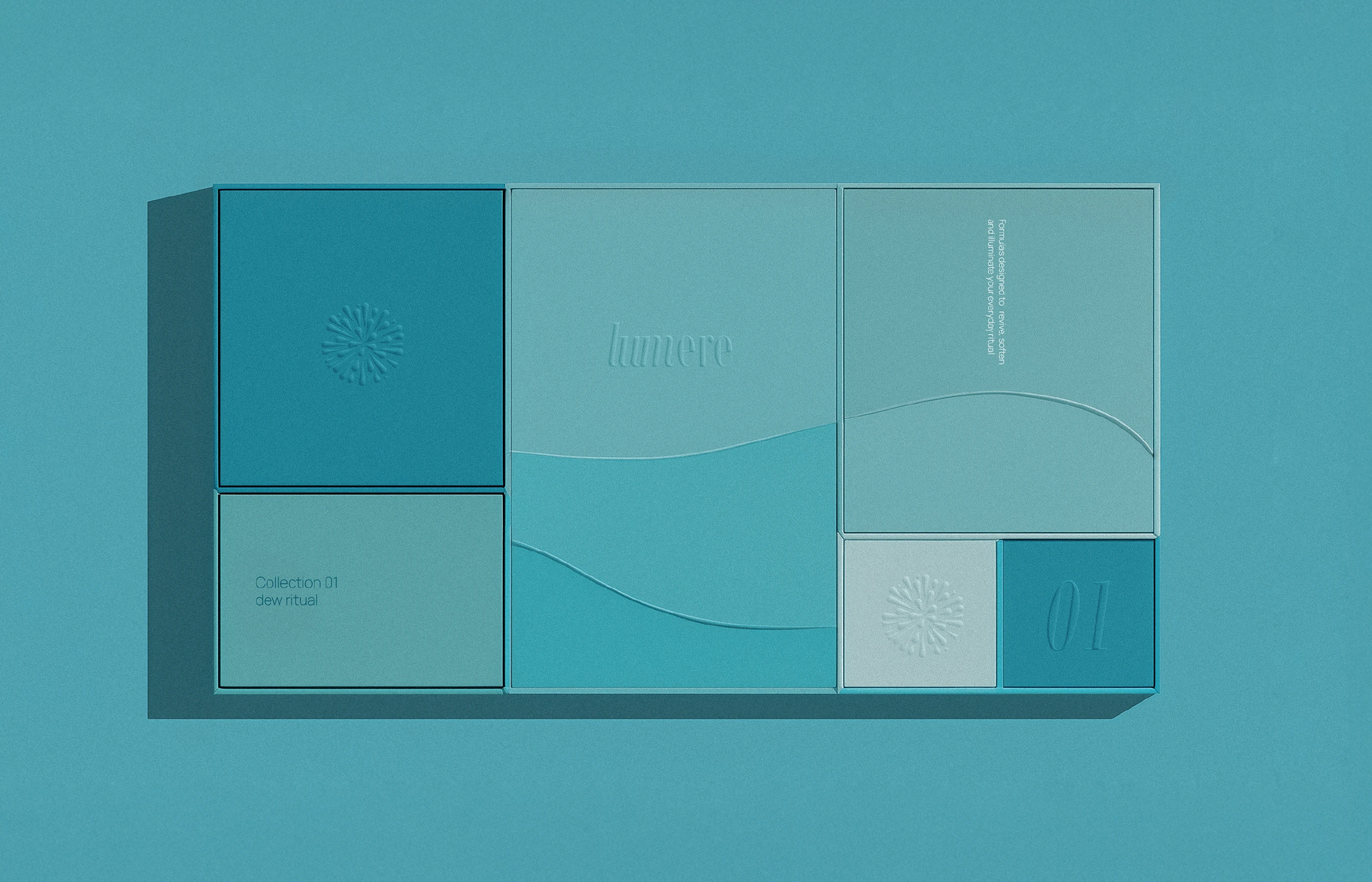 A top-down view of a segmented Lumere collection box. Five rectangular panels in a gradient of teal tones are arranged in a grid. The central panel features the 'lumere' logo in subtle embossed serif type, set against a two-tone wave pattern.