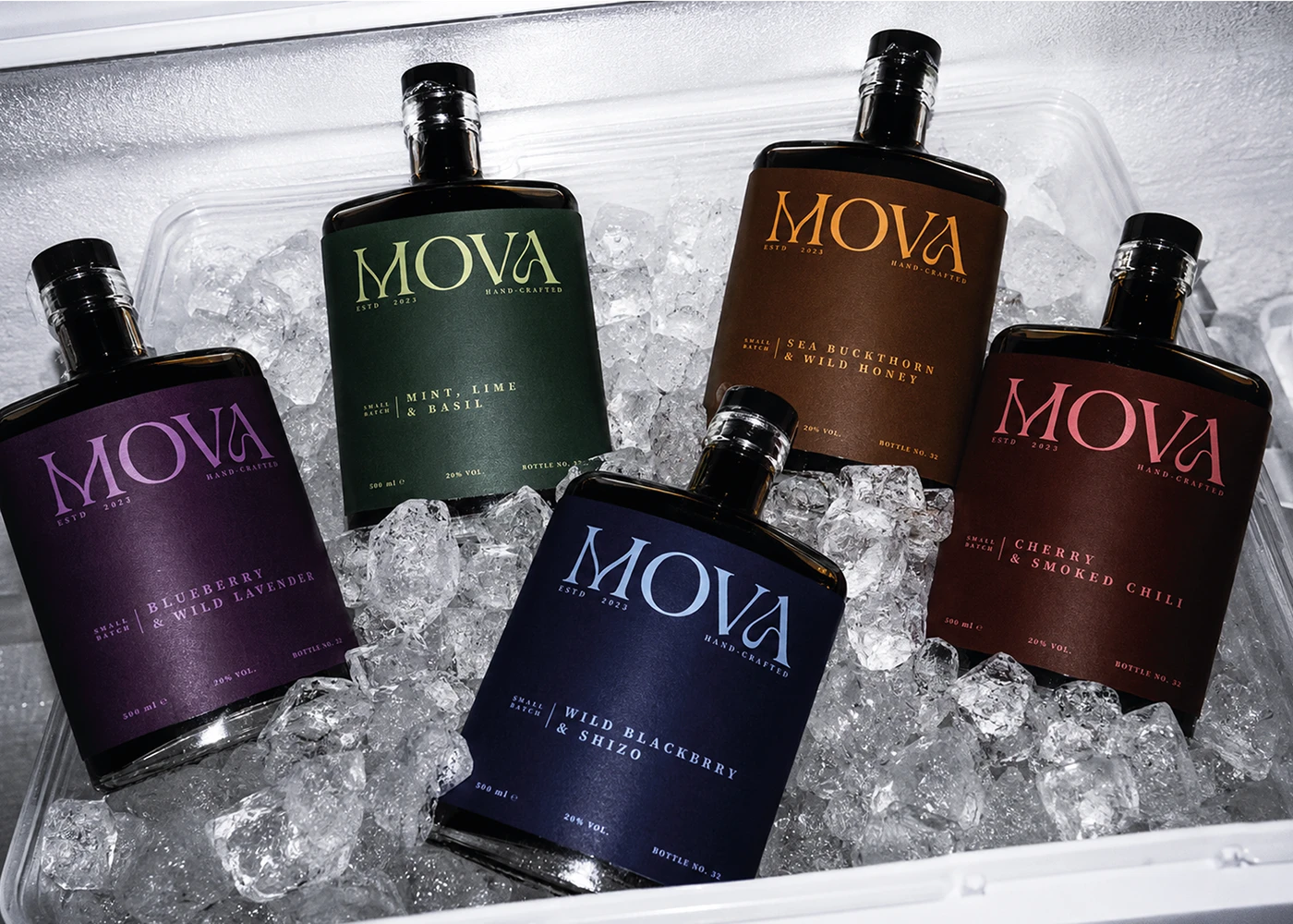 Five MOVA handcrafted fruit liqueur bottles with color-coded minimalist labels arranged on crushed ice.