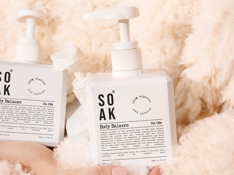 Soak Body Balance pump bottles with clean black-and-white labels photographed against soft cream wool texture.
