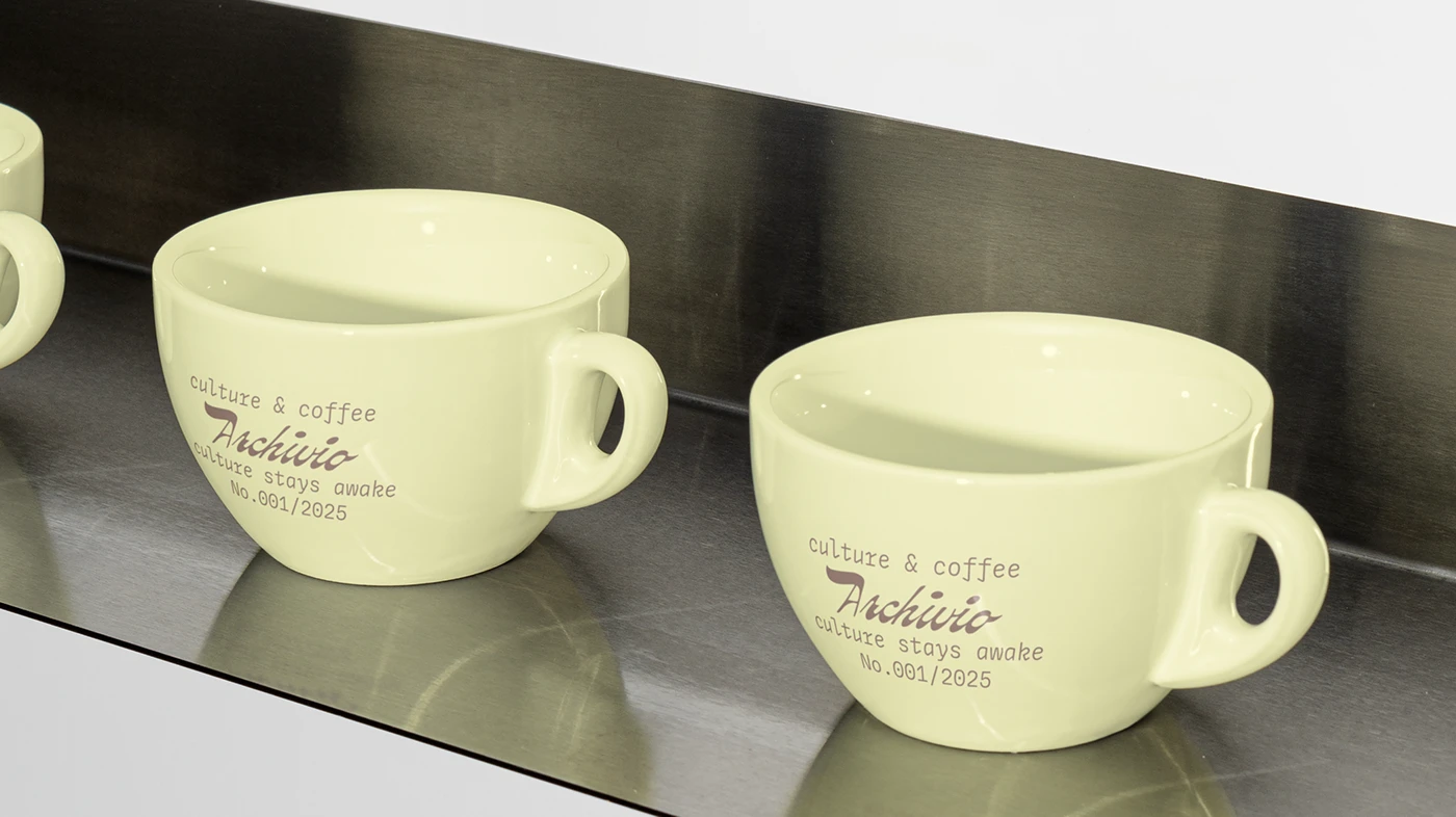 Archivio Coffee Cultura pastel ceramic coffee cups featuring printed logo, issue number typography, and minimalist café branding details.