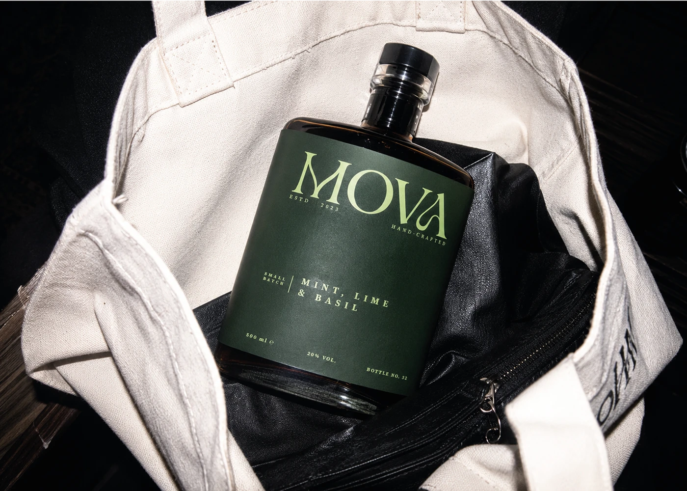 MOVA mint, lime and basil fruit liqueur bottle styled inside a white canvas tote bag.