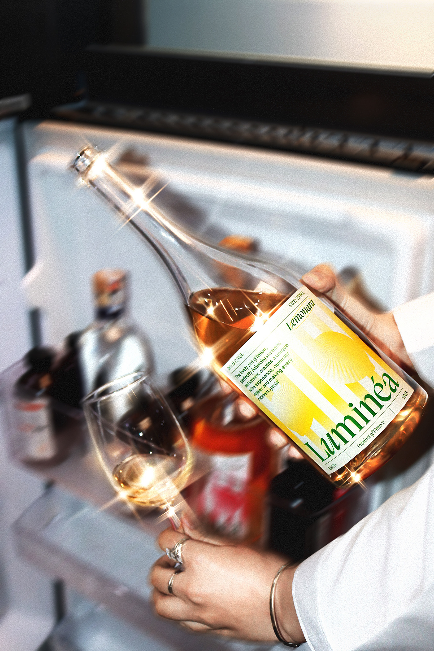 Person pouring a glass of Luminéa Lemonana wine straight from the bottle in front of an open refrigerator, highlighting the brand’s yellow gradient label and modern beverage packaging design.