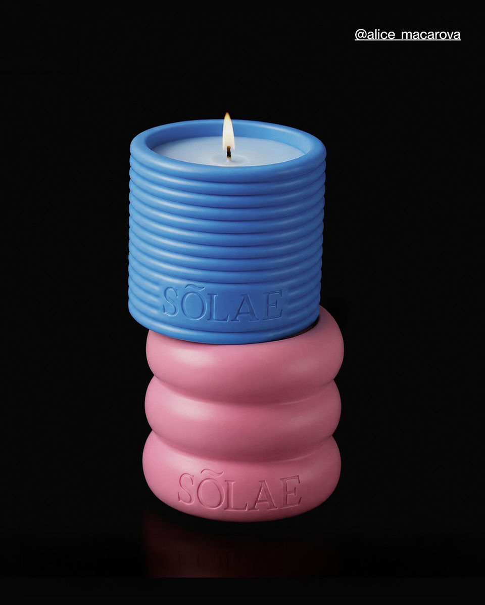 Sōlae sculptural candle vessels by Alice Macarova shown stacked in blue and pink with embossed logo details and a lit candle against a black background.