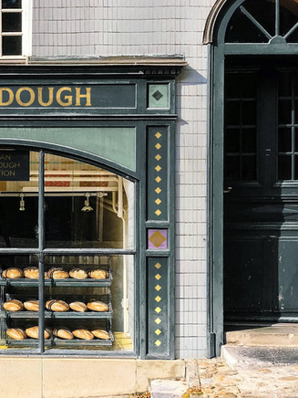 Uncle Dough bakery window display with fresh loaves on metal racks inside storefront