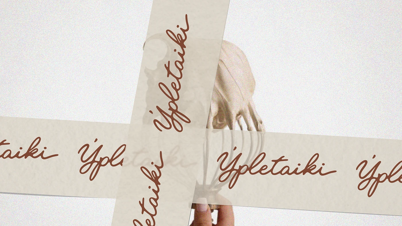 Close-up of Ypletaiki script logo printed on translucent packaging tape, showcasing cohesive brand identity and signature handwritten typography.