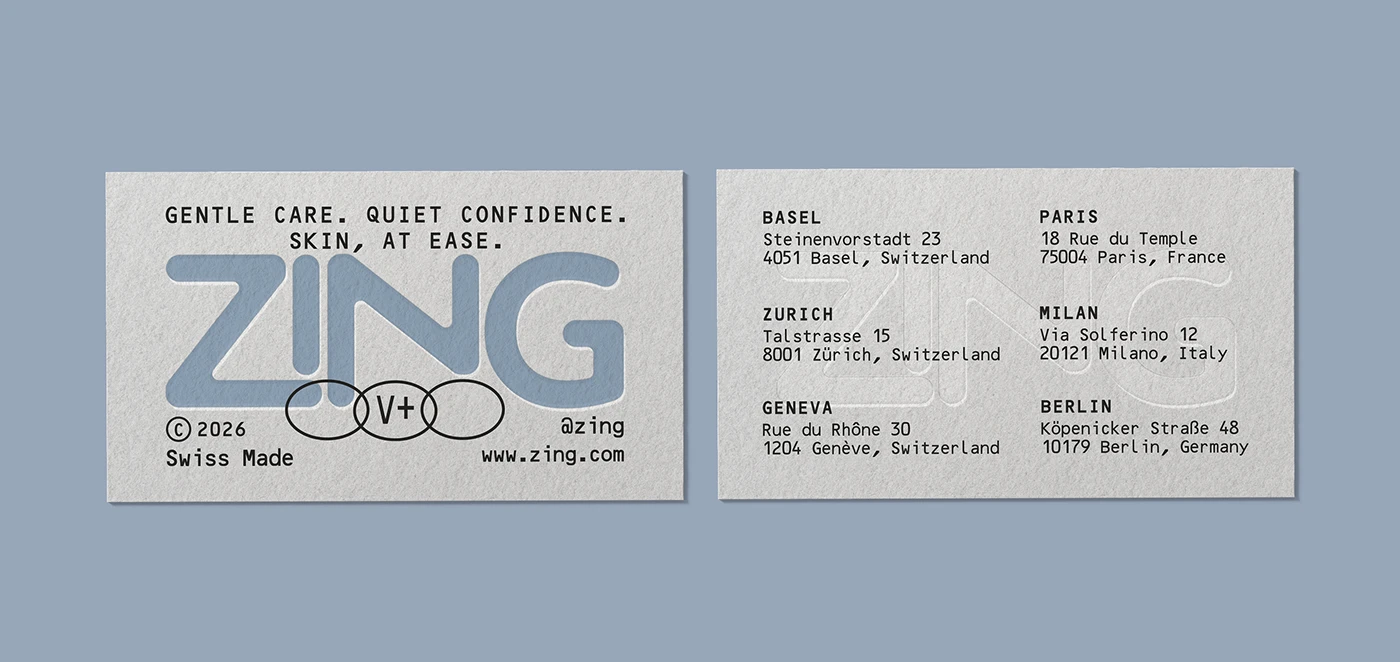 ZING skincare brand business cards shown on a soft blue background, featuring a pale blue logo, textured paper, minimal black typography, and global store location details.